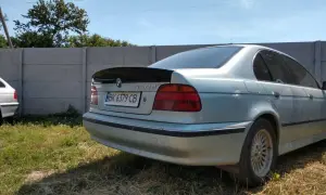 Srebrne BMW E39 z czarnym spoilerem na klapie bagażnika.
