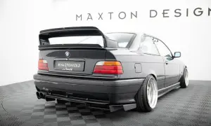Czarne BMW E36 z tuningowym zderzakiem, dyfuzorem i dużym spoilerem.