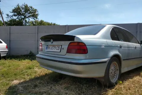 Srebrne BMW E39 z czarnym spoilerem na klapie bagażnika.