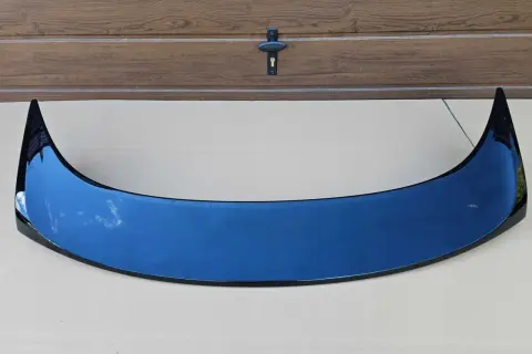 Czarny spoiler typu Type R do Hondy Accord VI na tle drewnianej bramy.