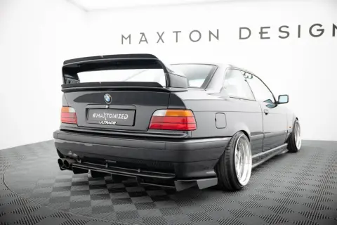 Czarne BMW E36 z tuningowym zderzakiem, dyfuzorem i dużym spoilerem.