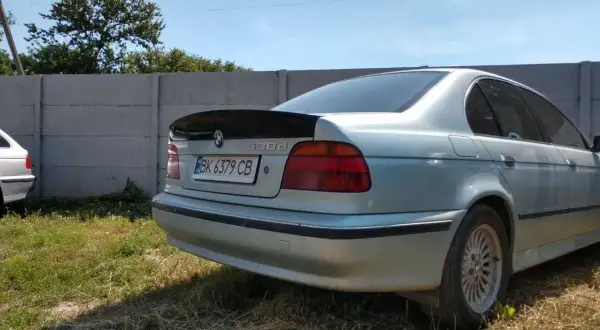 Srebrne BMW E39 z czarnym spoilerem na klapie bagażnika.