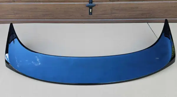 Czarny spoiler typu Type R do Hondy Accord VI na tle drewnianej bramy.