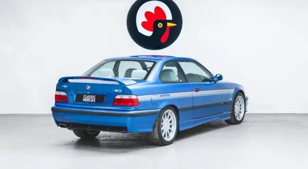 Niebieskie BMW E36 M3 z naklejkami Hartge, widok z tyłu.