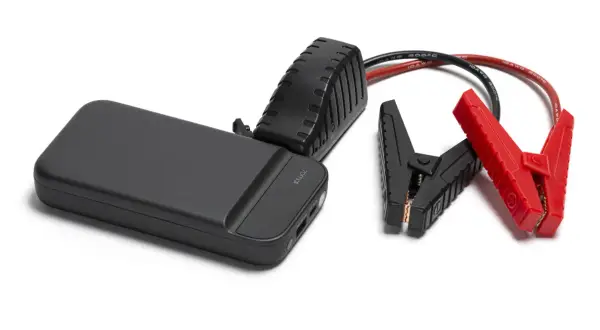 Czarny jump starter z czerwonymi i czarnymi klemami na białym tle.