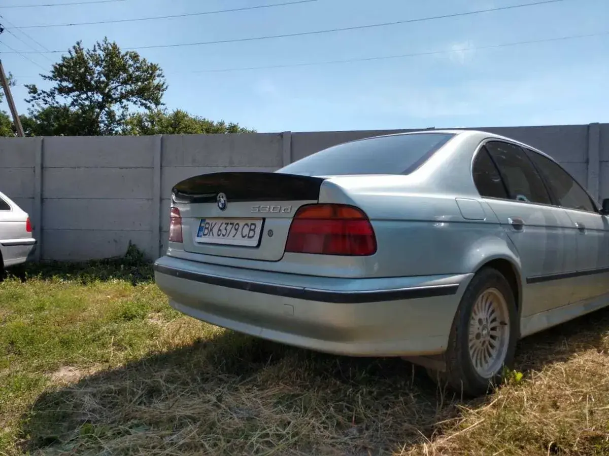 Srebrne BMW E39 z czarnym spoilerem na klapie bagażnika.